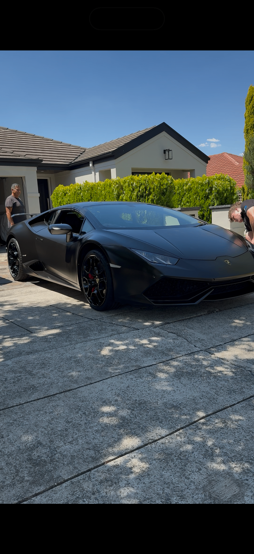 Matte black Lamborghini Huracán being detailed on driveway